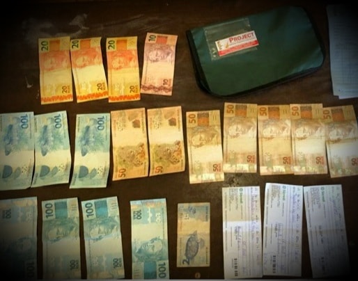 Dinheiro, cheques e outros materiais apreendidos com os estelionatários (Foto: Divulgação/BM)