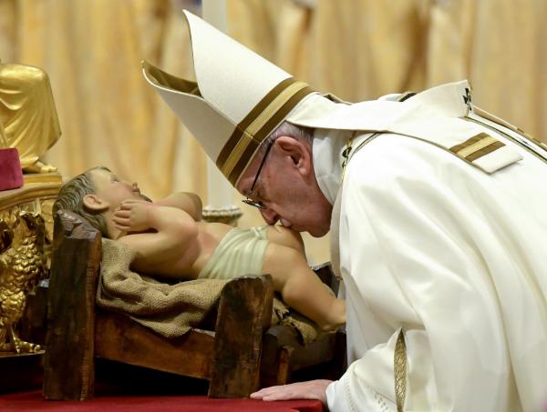 Papa Francisco beja a imagem do menino Jesus durante a Missa do Galo (Foto: Tiziana Fabi/AFP)