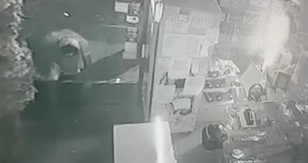 Momento em que criminoso quebra o vidro da porta e invade o estabelecimento comercial (Foto: Reprodução)