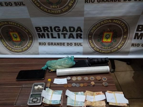 Dinheiro em cédulas e moedas, drogas e outros objetos apreendidos com o indivíduo (Foto: Divulgação/Brigada Militar)