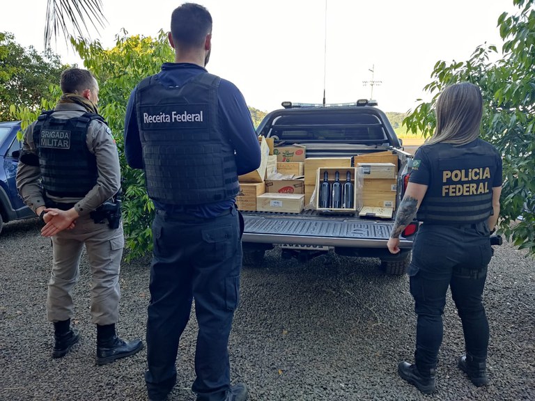 Agentes diante de caixas de vinhos que foram apreendidas (Foto: Divulgação)