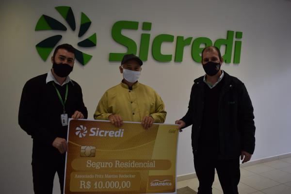Entrega do prêmio ao associado da Sicredi Raízes RS/SC/MG, Fritz Martim Redecker, da agência de São Miguel do Oeste/SC (Foto: Divulgação/Sicredi)