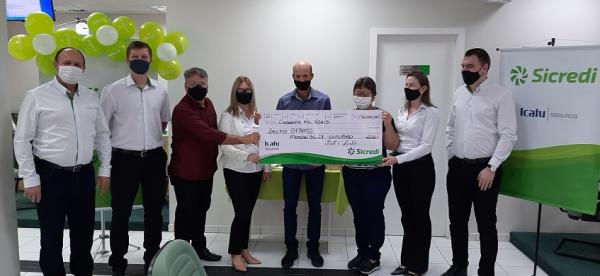 Entrega simbólica do valor de R$ 50 mil ao associado Selmo Staats, da agência de Mondaí/SC (Foto: Divulgação/Sicredi Raízes)