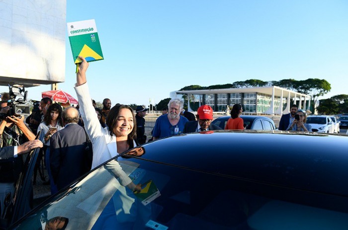 Na Praça dos Três Poderes, a relatora, Eliziane Gama, exibe exemplar da Constituição, após aprovação do relatório - Foto: Marcos Oliveira/Agência Senado